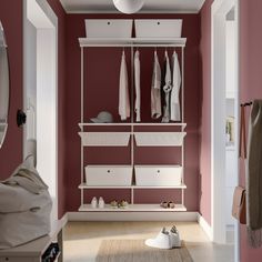 a room with red walls and white shelves filled with clothes, shoes and other items