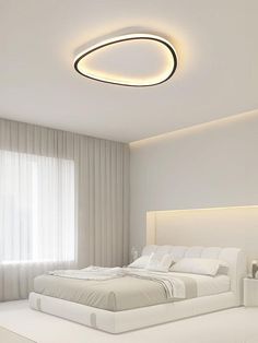 a modern bedroom with white walls and flooring is lit up by the ceiling lights