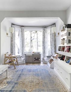 a living room filled with furniture and a large rug on top of a carpeted floor