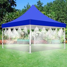 a blue and white tent sitting on top of a lush green field