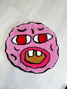 a pink rug with an angry face drawn on it