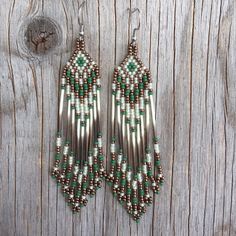 green and silver beaded earrings on wooden background