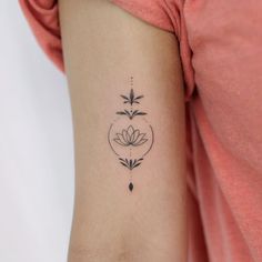 a woman's arm with a small flower tattoo on the left side of her arm