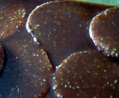 some cookies are covered in chocolate and sprinkled with flecky powdered sugar