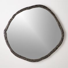 a mirror that is on the wall with some kind of metal thing in it's frame