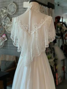 the back of a wedding dress on display in a room full of other items and accessories