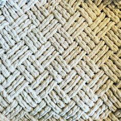 closeup of the texture of a carpet with white and beige colors, including braiding