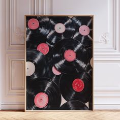 an art piece with black and pink vinyl records on it in front of a white wall