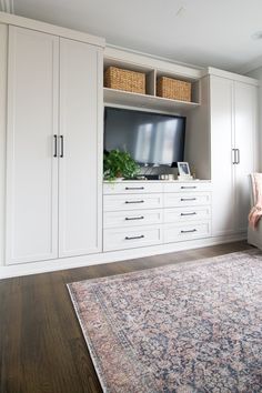 a living room filled with furniture and a flat screen tv on top of a cabinet