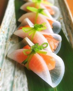 several pieces of sushi sitting on top of a green leaf