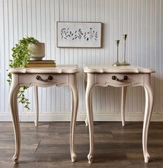 two white tables sitting next to each other on top of a hard wood floored floor