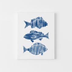 three blue fish are on a white wall