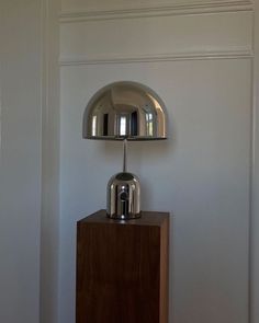 a chrome lamp on top of a wooden table