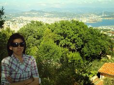 a woman standing on top of a lush green hillside