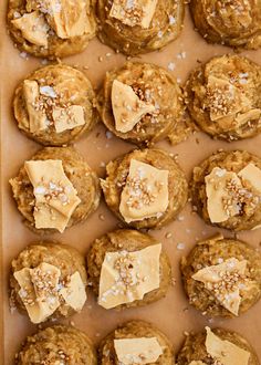 a tray filled with cookies covered in peanut butter and topped with flaky toppings