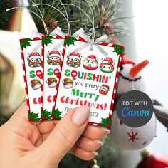 someone holding three christmas gift tags in their hand