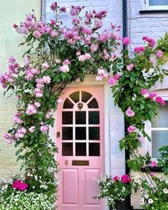 a pink door surrounded by flowers and plants