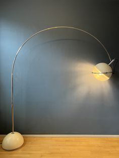 a lamp that is on top of a wooden floor next to a wall with a blue background