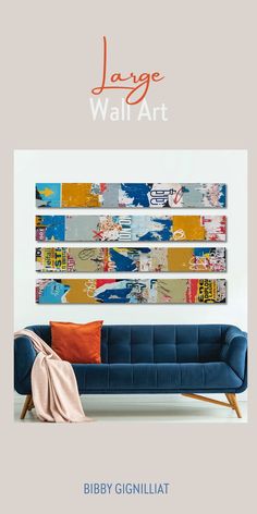 the large wall art is hanging above a blue couch