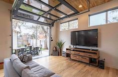 a living room with a couch, television and sliding glass doors