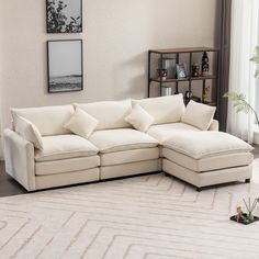 a living room with a sectional couch and white rugs on the floor in front of a window