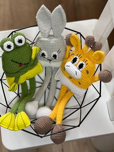 three crocheted stuffed animals sitting on top of a white chair next to each other