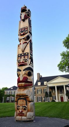 a totem pole in front of a large house