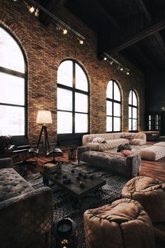 a living room filled with lots of furniture and large windowed windows next to each other