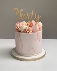 a pink and gold cake with the word forty on top