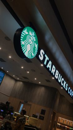 the starbucks sign is lit up above the counter