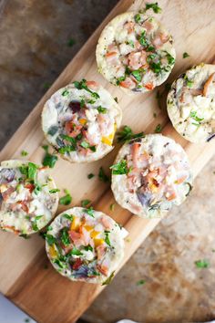 several small muffins with different toppings on a cutting board