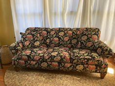 a couch sitting on top of a rug in front of a window