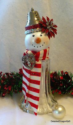 a snowman figurine with a red and white striped scarf