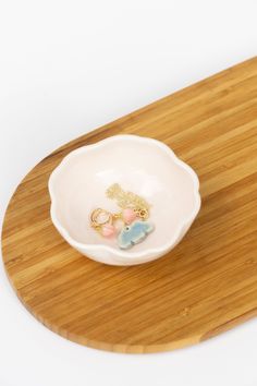 a small white bowl sitting on top of a wooden tray