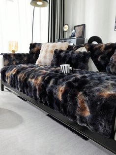 a black and brown couch sitting in front of a mirror