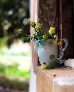 a vase with flowers in it sitting on a ledge