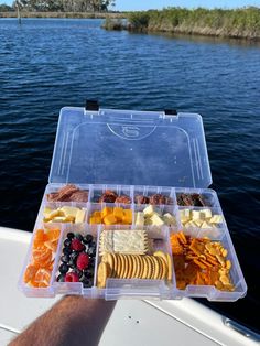 a plastic container filled with lots of different types of food on top of a boat