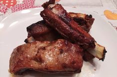 two pieces of meat sitting on top of a white plate