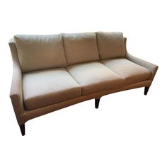 a beige couch sitting on top of a white floor