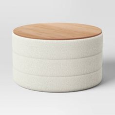 a round white container with a wooden lid