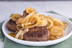 a white plate topped with pasta and meatballs on top of a green table cloth