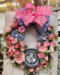 a wreath with pink flowers and blue plates