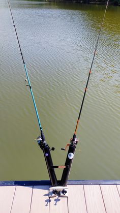 two fishing rods sitting on top of a wooden dock