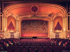 an empty theater with rows of seats facing the stage