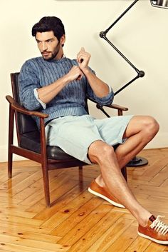 a man sitting in a chair with his fist raised up while looking at the camera