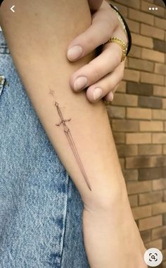 a woman's arm with a cross tattoo on the left side of her arm