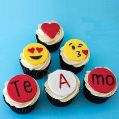 some cupcakes with icing that have faces and hearts on them are arranged in the shape of letters