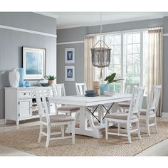 a white dining room table and chairs in front of a window