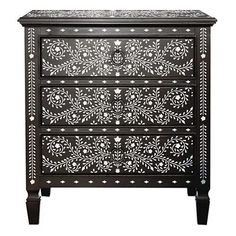 an ornate black and white cabinet with drawers