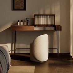 a bed room with a neatly made bed next to a wooden table and window sill